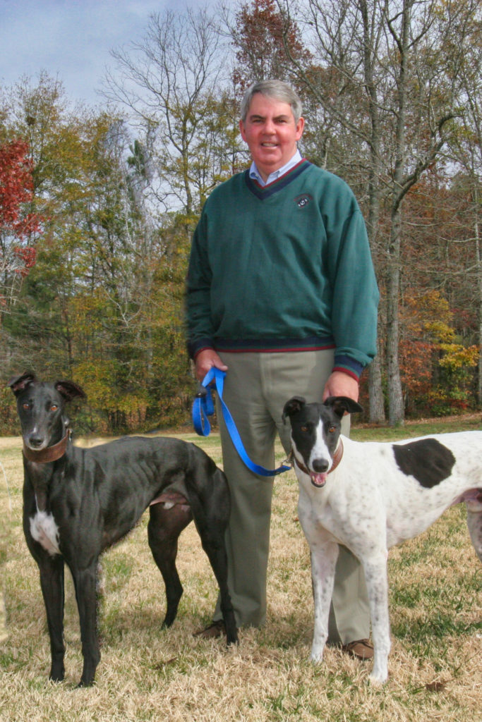 Greyhound Nation host, John Parker, with Greyhounds, Cole (left) and Basso Profondo (right).